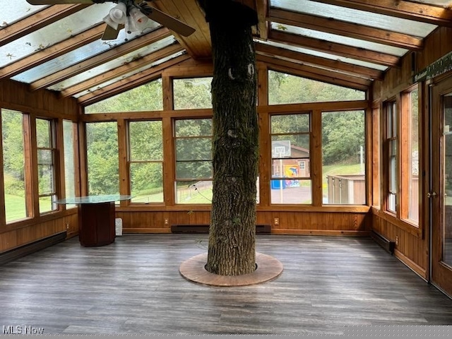 unfurnished sunroom with wood walls, wood finished floors, a healthy amount of sunlight, and vaulted ceiling with beams