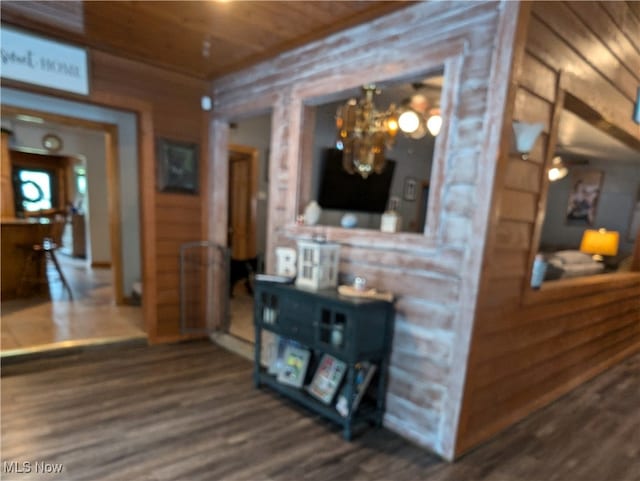 hall featuring a notable chandelier, wood ceiling, wood walls, and hardwood / wood-style flooring