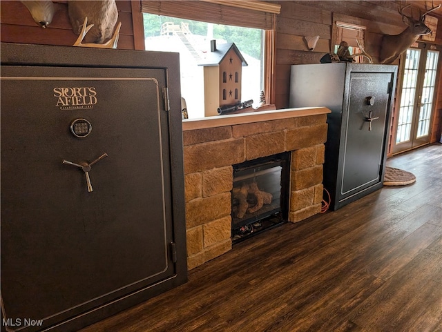 details featuring a stone fireplace, wood walls, and hardwood / wood-style floors