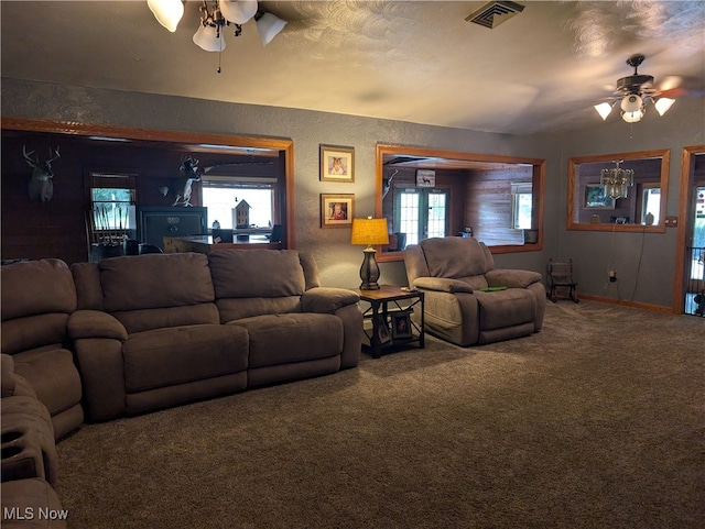 carpeted living room featuring ceiling fan and a textured ceiling