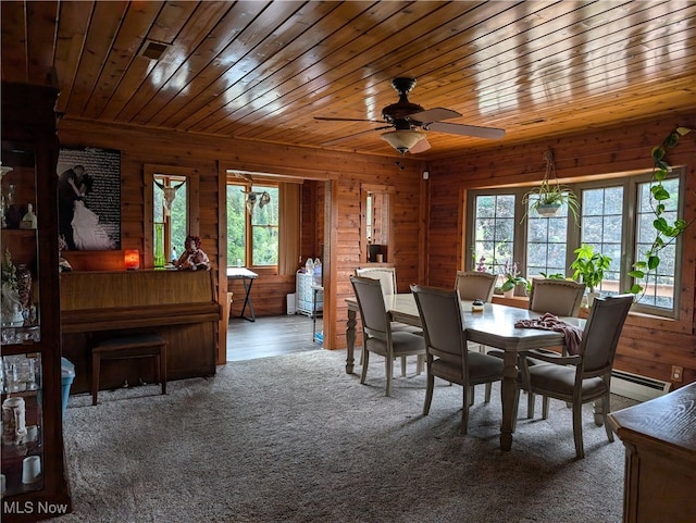 dining room featuring ceiling fan, wooden walls, carpet, and wooden ceiling