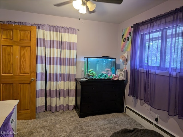 carpeted bedroom featuring ceiling fan and a baseboard heating unit