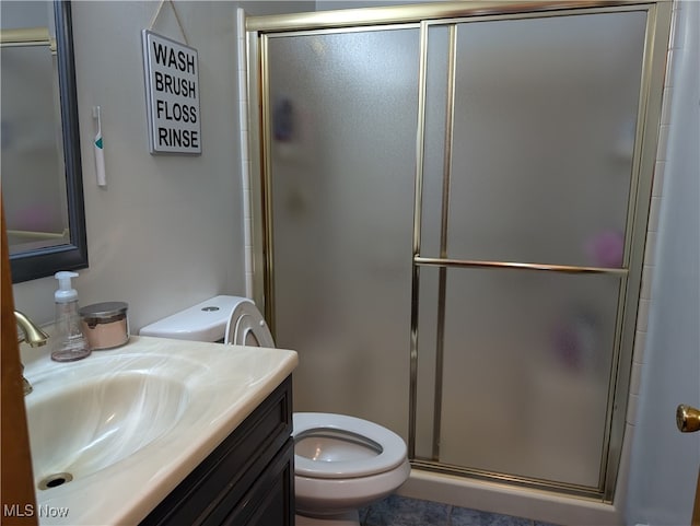 bathroom with vanity, a shower with shower door, and toilet