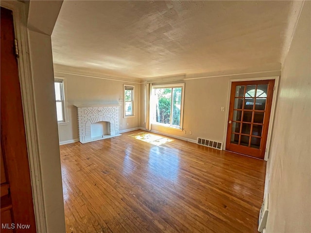 unfurnished living room with hardwood / wood-style flooring and a fireplace