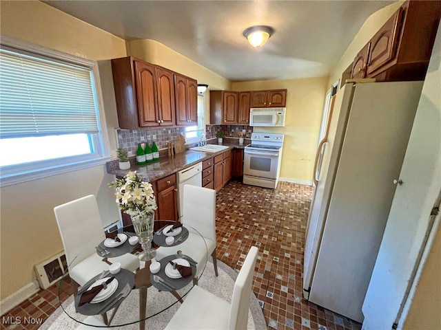 kitchen with sink, white appliances, and decorative backsplash