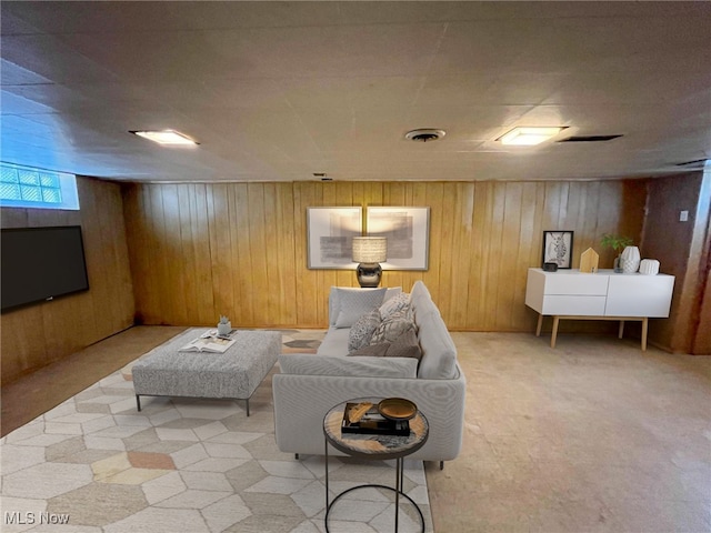 living room with wooden walls and light colored carpet