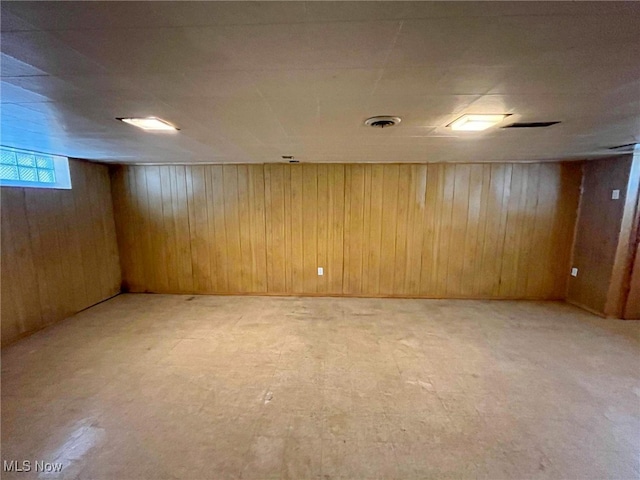 basement featuring wooden walls