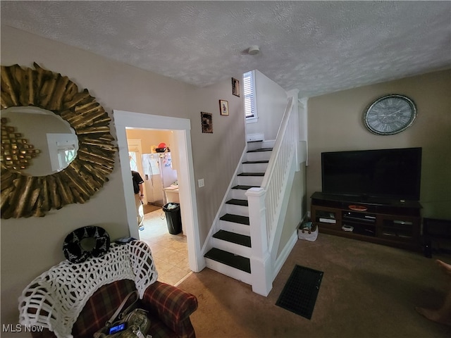 carpeted living room with a textured ceiling