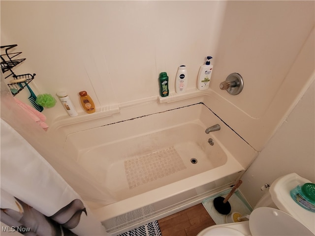 bathroom featuring toilet and shower / bath combination