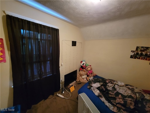 unfurnished bedroom with lofted ceiling, carpet floors, and a textured ceiling