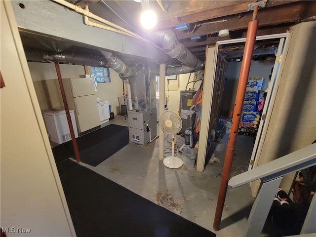 basement with white refrigerator, refrigerator, heating unit, and water heater