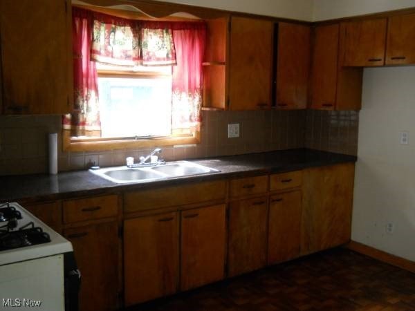 kitchen with tasteful backsplash, gas range gas stove, and sink