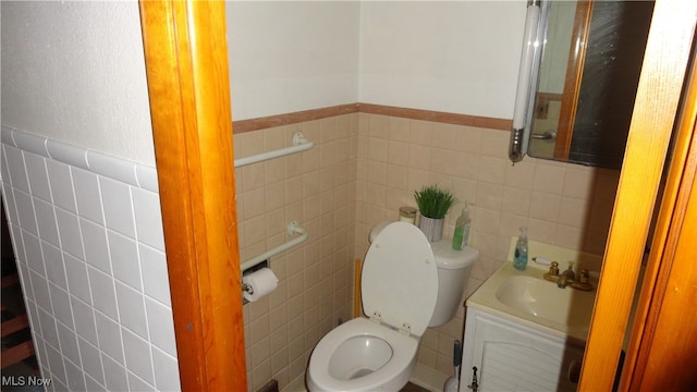 bathroom featuring vanity, toilet, and tile walls