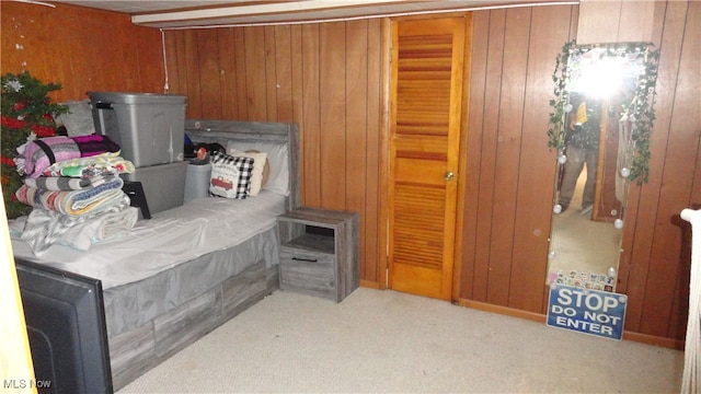 bedroom featuring carpet flooring and wooden walls