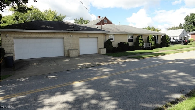 view of side of home featuring a lawn and a garage