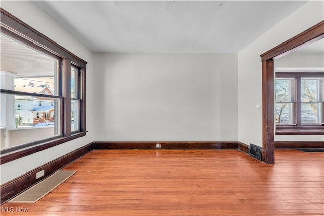 spare room with a healthy amount of sunlight and light hardwood / wood-style flooring