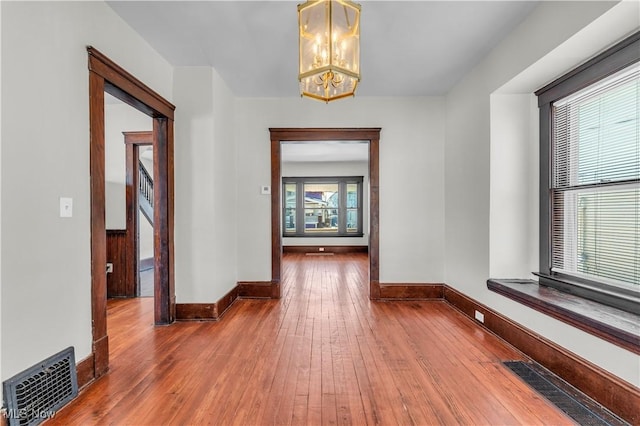 hall featuring hardwood / wood-style floors and an inviting chandelier