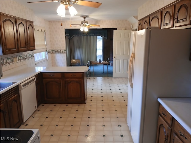 kitchen featuring kitchen peninsula, dark brown cabinets, white appliances, and ceiling fan