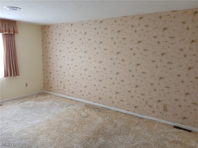 carpeted empty room with a textured ceiling