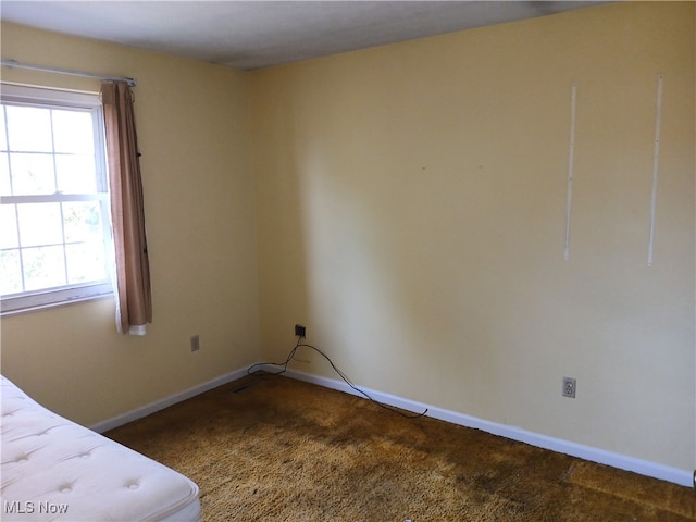 unfurnished bedroom with dark colored carpet