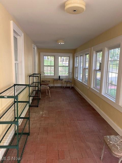 837 Quincy St, Parkersburg, WV 26101 - unfurnished sunroom featuring baseboards and brick patterned floors
