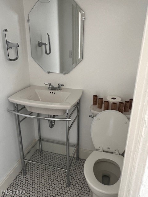 bathroom with tile patterned flooring, toilet, and baseboards