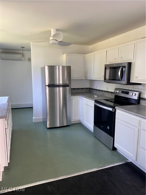 kitchen with stainless steel appliances, baseboards, ceiling fan, and white cabinetry