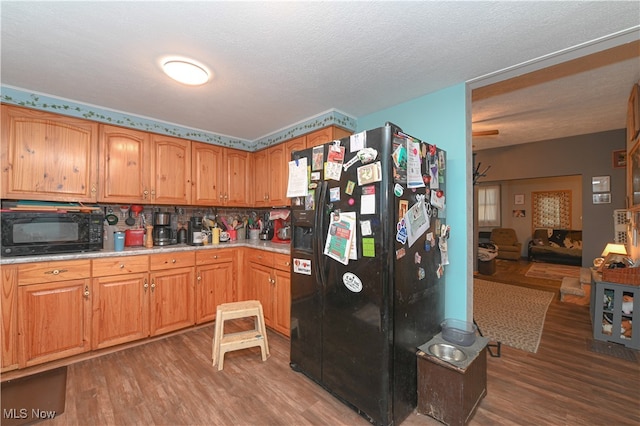 kitchen featuring black appliances, a textured ceiling, tasteful backsplash, and dark hardwood / wood-style flooring