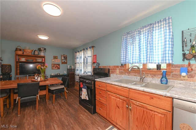 kitchen with stainless steel dishwasher, sink, black range with gas stovetop, and dark hardwood / wood-style flooring