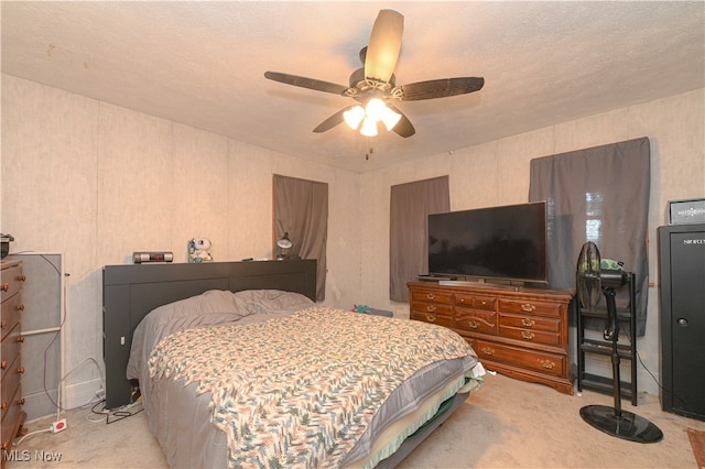 bedroom featuring ceiling fan, a textured ceiling, and light carpet