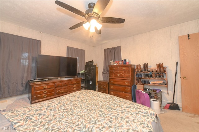 carpeted bedroom with ceiling fan and a textured ceiling