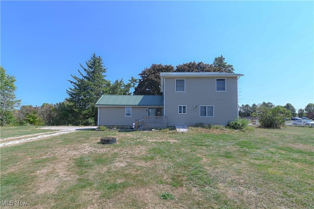 rear view of property featuring a lawn