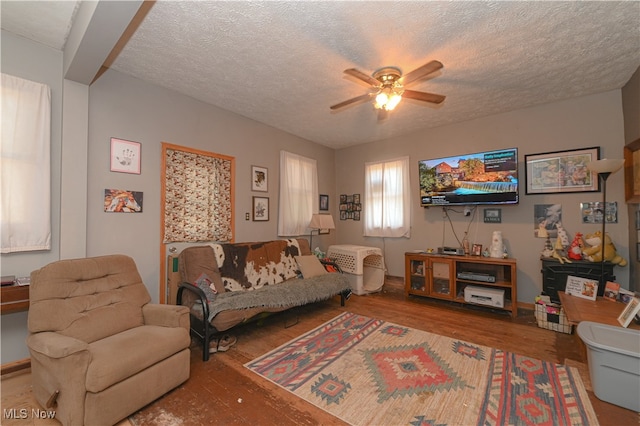 living room featuring ceiling fan, a textured ceiling, and hardwood / wood-style floors