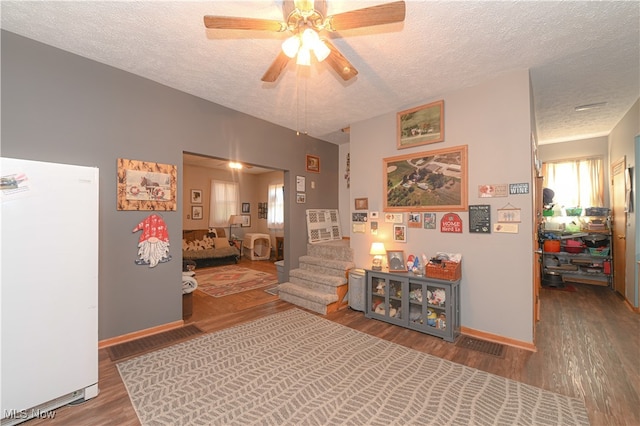 interior space with ceiling fan, a textured ceiling, and hardwood / wood-style flooring