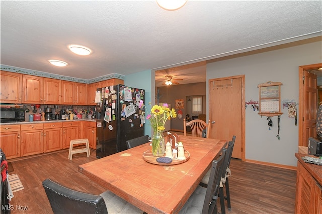 dining space with a textured ceiling, ceiling fan, and dark wood-type flooring