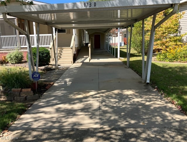 view of parking with a lawn and a carport