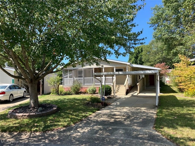 manufactured / mobile home with a porch, a front lawn, and a carport