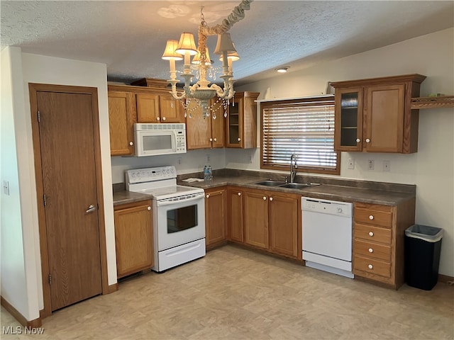 kitchen with pendant lighting, a notable chandelier, white appliances, a textured ceiling, and sink