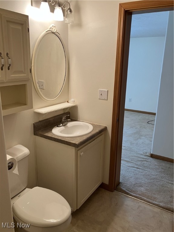 bathroom featuring vanity, toilet, and tile patterned floors