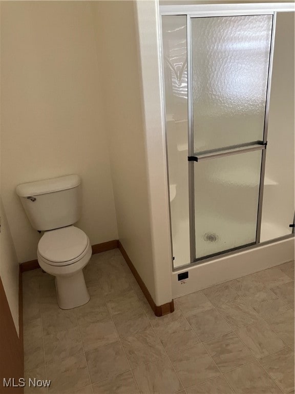 bathroom featuring toilet and an enclosed shower