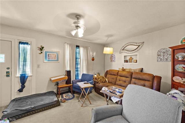 carpeted living room with ceiling fan