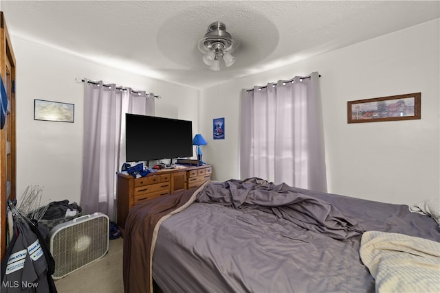 bedroom featuring ceiling fan and a textured ceiling