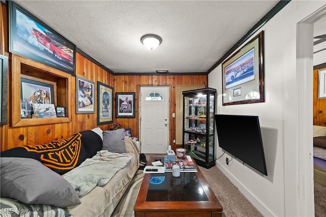 carpeted living room with ornamental molding, a textured ceiling, and wooden walls