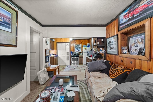 living room featuring carpet floors, a textured ceiling, wooden walls, and ornamental molding