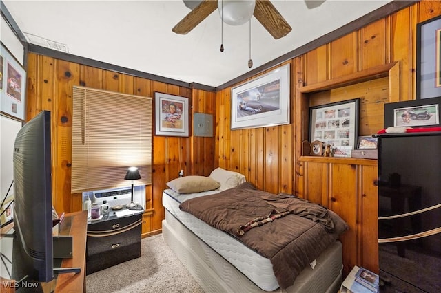 carpeted bedroom featuring ceiling fan and wood walls