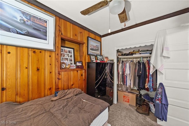 bedroom with carpet floors, a closet, wood walls, and ceiling fan