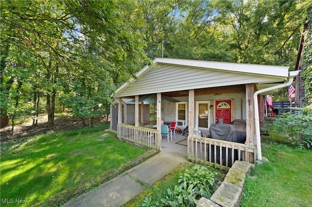 view of outdoor structure with covered porch and a lawn