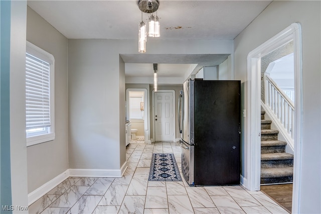 interior space featuring pendant lighting and stainless steel refrigerator