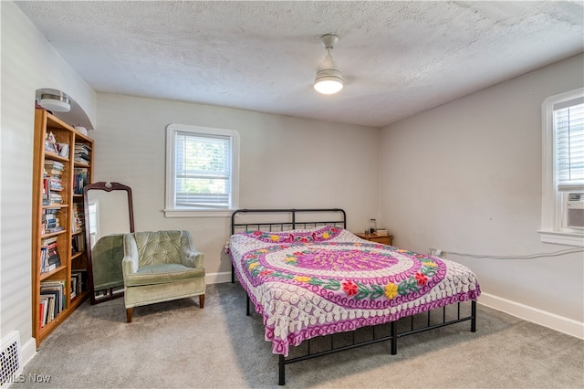 bedroom featuring ceiling fan, a textured ceiling, and carpet floors