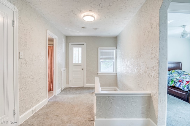 corridor with a textured ceiling and carpet